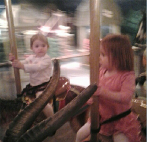 Riding on the carousel with her cousin and friend Lucy!